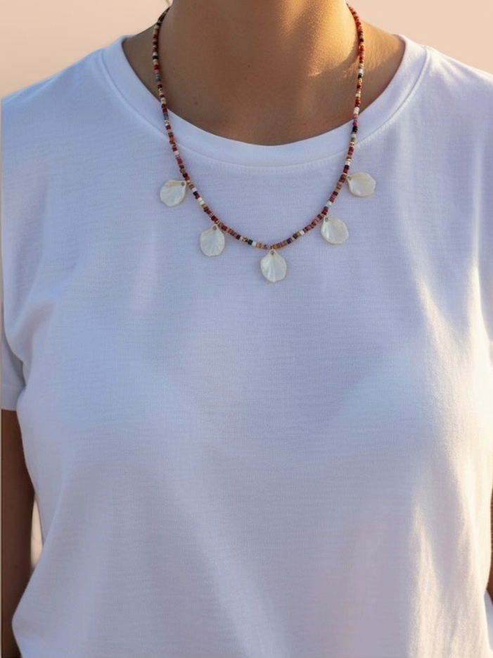 Craft and Babble beaded necklace with multi-coloured glass beads and five iridescent shell charms on a white t-shirt