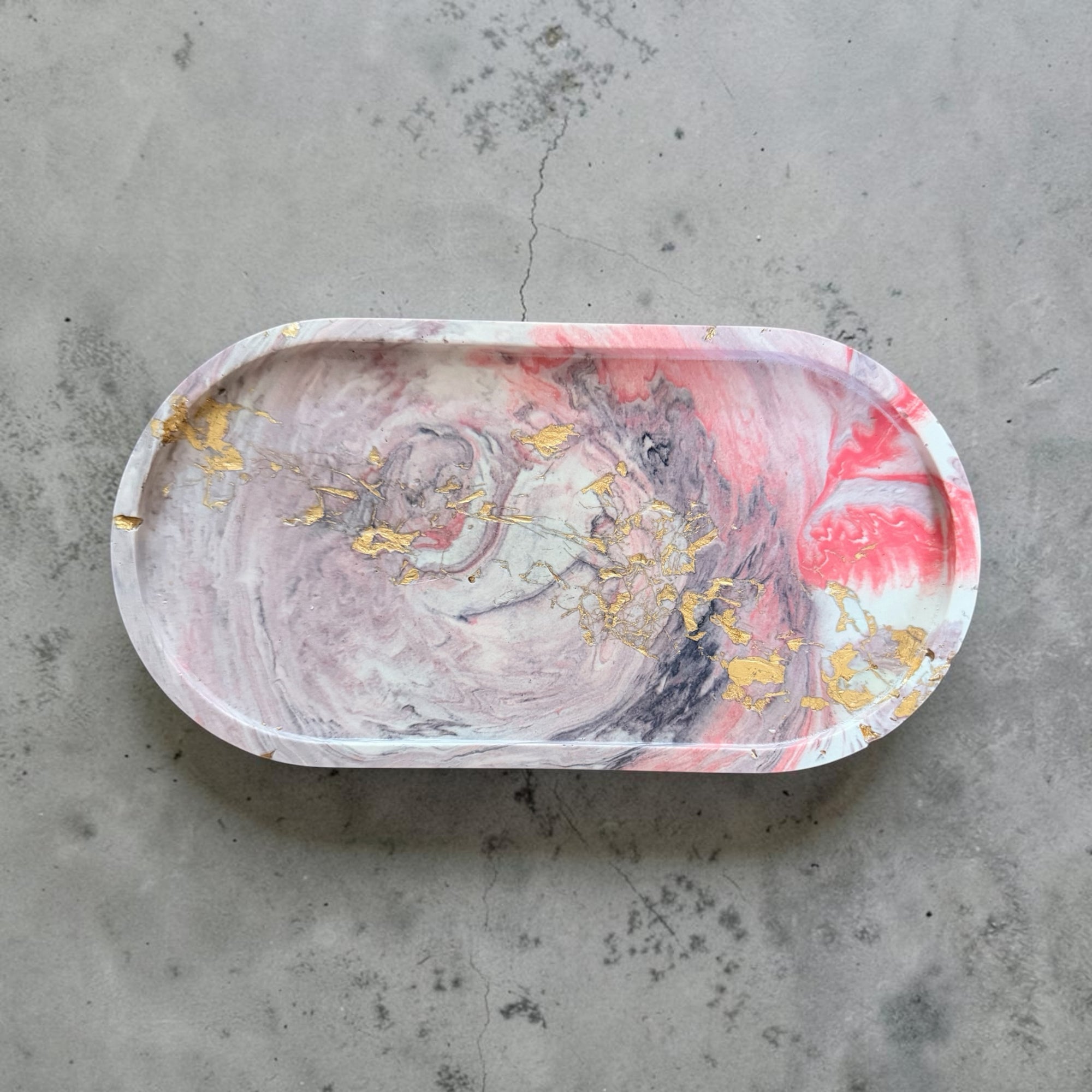 Craft and Babble oval resin trinket tray with a pink, grey, and white marbled pattern and gold leaf accents.
